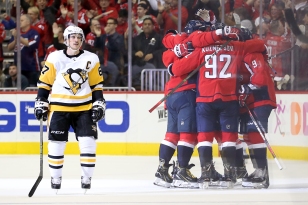 WASHINGTON, DC - NOVEMBER 07: Sidney Crosby #87 of the Pittsburgh Penguins skates past as T.J. Oshie #77 of the Washington Capitals celebrates with teammates after scoring the game winning goal during the third period at Capital One Arena on November 7, 2018 in Washington, DC. (Photo by Will Newton/Getty Images)